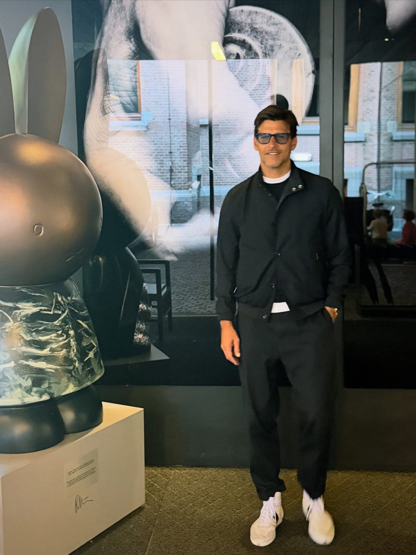 Person in a black jacket standing in a gallery