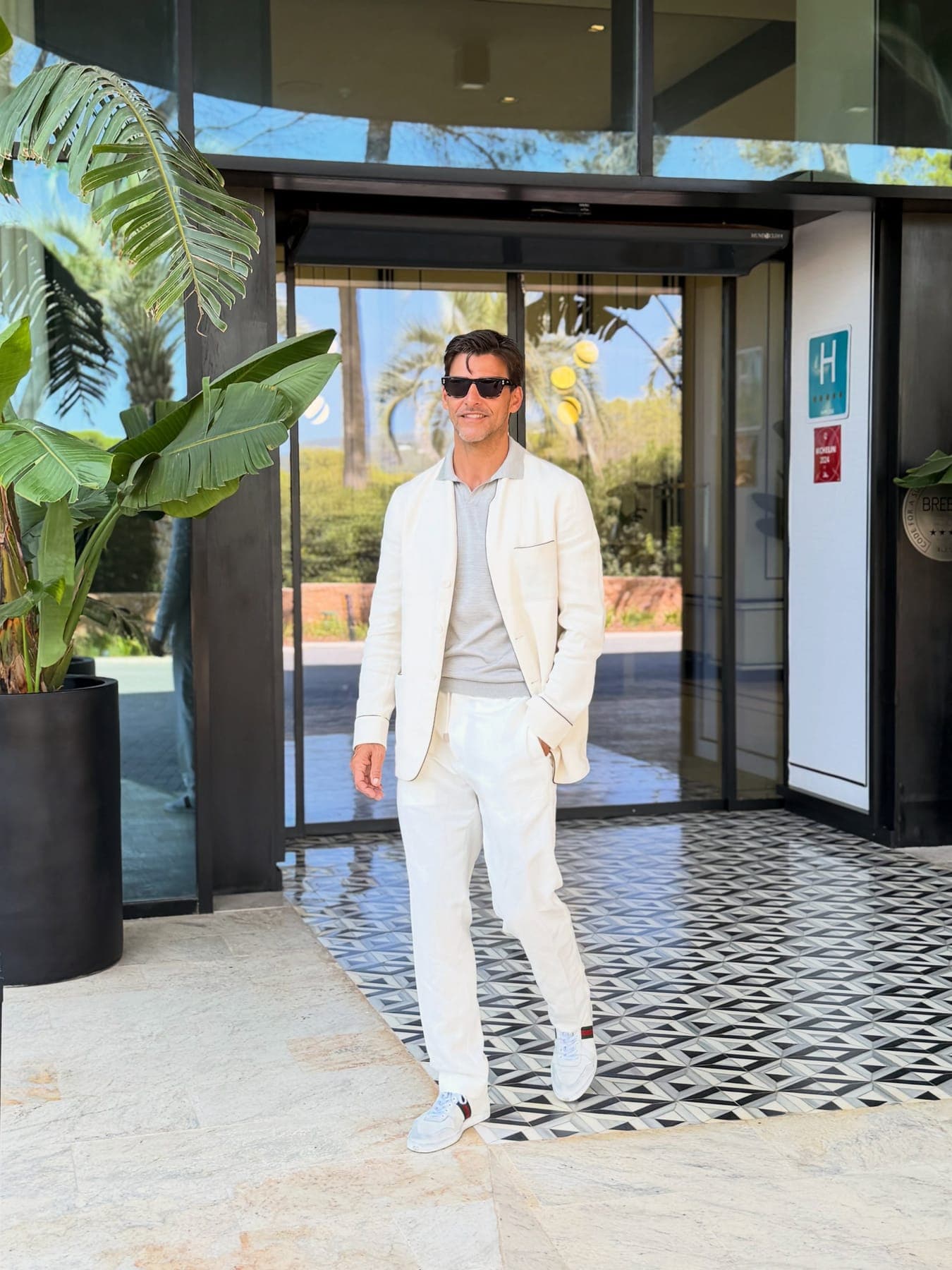 Person in white linen walking through a hotel lobby